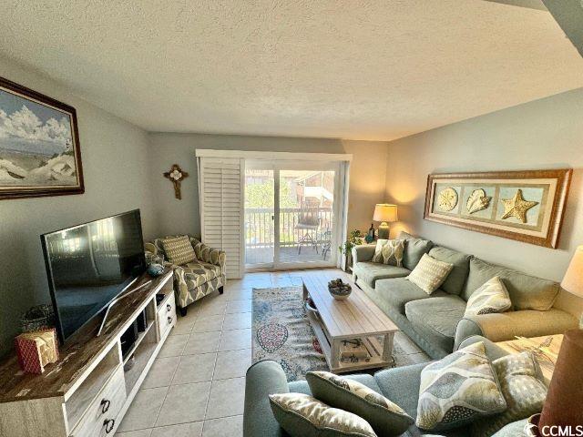 living room featuring a textured ceiling and light tile patterned floors