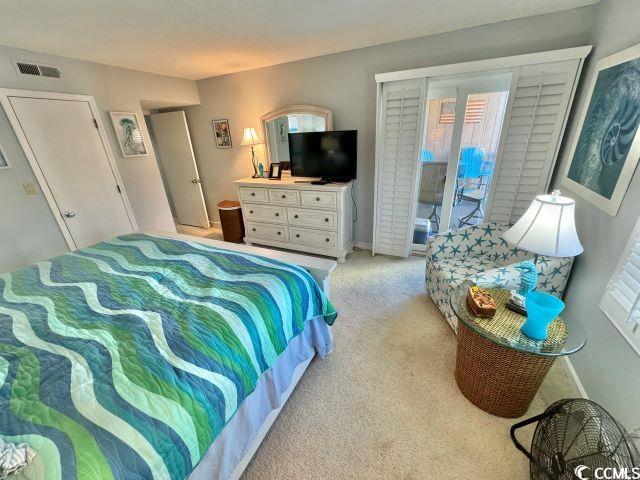 bedroom with light carpet, multiple windows, and access to exterior