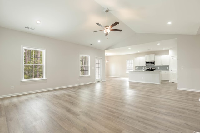 unfurnished living room featuring light wood-type flooring, ceiling fan, and vaulted ceiling