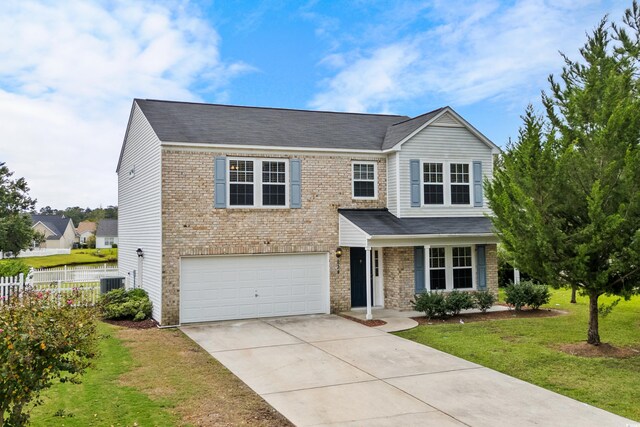 view of front of home with a front yard, a garage, and central AC unit