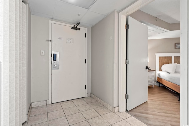 corridor featuring a drop ceiling and light tile patterned floors