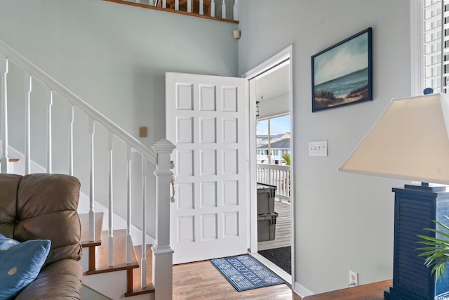 entrance foyer with a towering ceiling and hardwood / wood-style floors