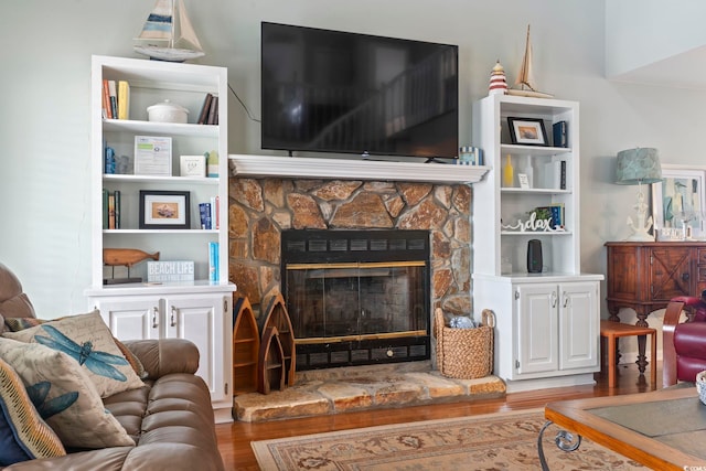 living room featuring a stone fireplace and hardwood / wood-style flooring