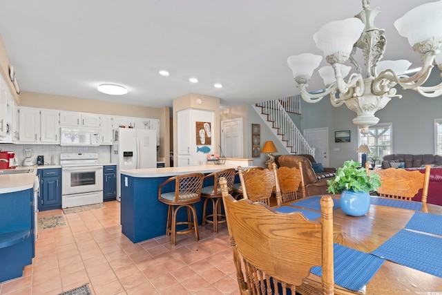 dining room featuring sink, an inviting chandelier, and light tile patterned floors