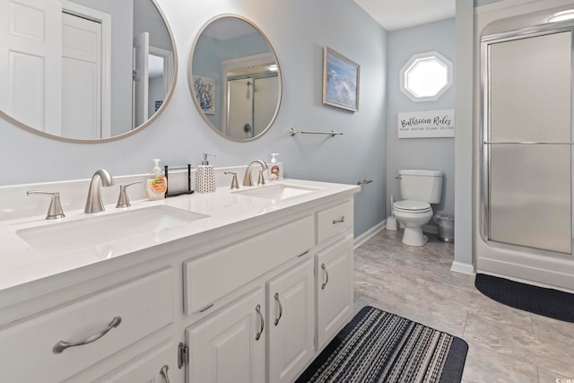 bathroom with a shower with shower door, vanity, and toilet