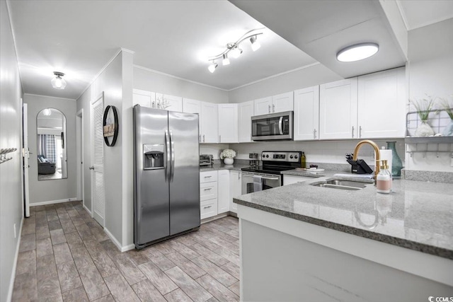 kitchen featuring white cabinets, dark stone countertops, sink, light hardwood / wood-style floors, and stainless steel appliances