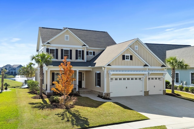 view of front of house featuring a front lawn, a garage, and a water view