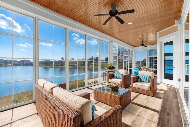 sunroom with plenty of natural light, ceiling fan, wood ceiling, and a water view