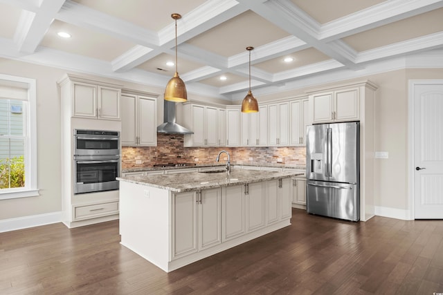 kitchen featuring stainless steel appliances, light stone counters, a center island with sink, wall chimney range hood, and pendant lighting