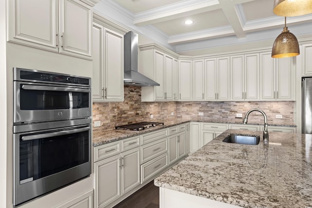 kitchen featuring sink, wall chimney exhaust hood, pendant lighting, beam ceiling, and appliances with stainless steel finishes