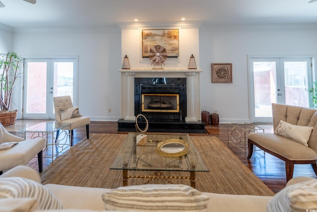 living room featuring dark wood-type flooring, french doors, ornamental molding, and plenty of natural light