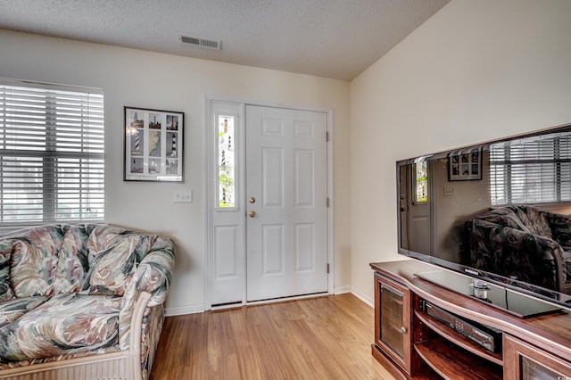 entryway with a textured ceiling and light wood-type flooring