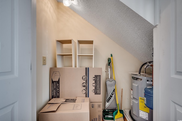 laundry area featuring electric water heater and a textured ceiling