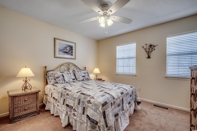 carpeted bedroom with a textured ceiling and ceiling fan