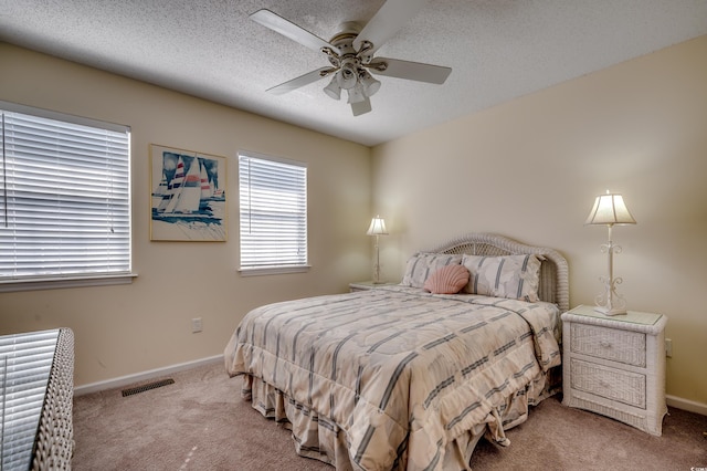 bedroom with a textured ceiling, carpet flooring, and ceiling fan