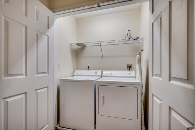 clothes washing area featuring separate washer and dryer