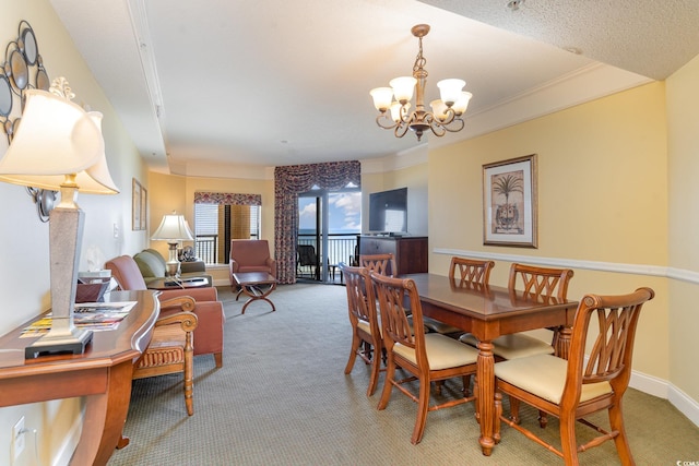 carpeted dining space featuring ornamental molding, a textured ceiling, and a chandelier