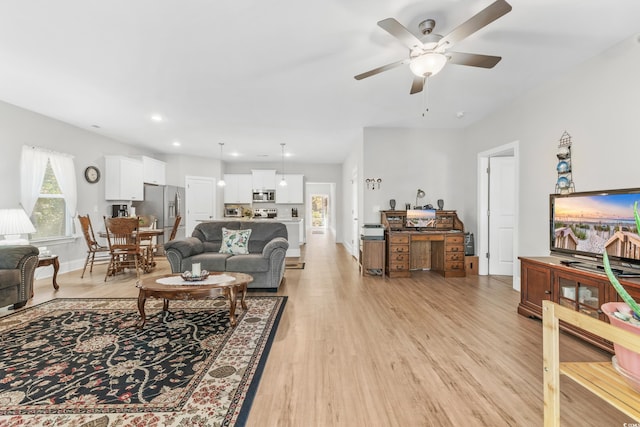 living room featuring light hardwood / wood-style flooring and ceiling fan