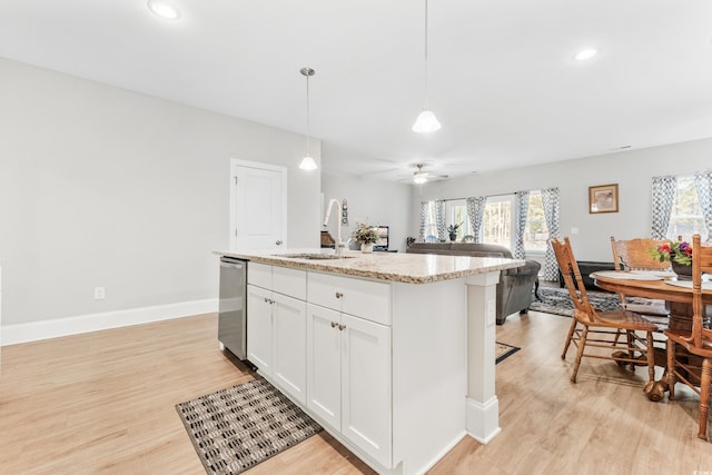 kitchen with light hardwood / wood-style flooring, sink, plenty of natural light, and a kitchen island with sink