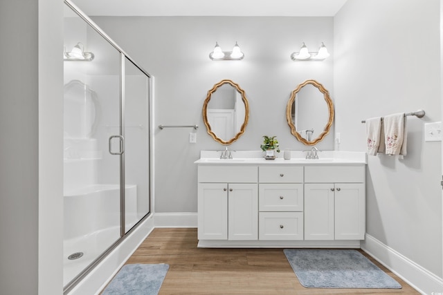 bathroom with vanity, an enclosed shower, and hardwood / wood-style flooring