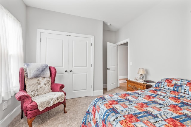 bedroom featuring light colored carpet and a closet