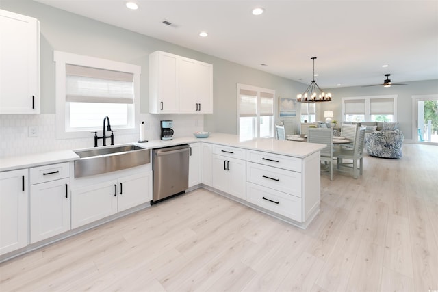 kitchen featuring sink, stainless steel dishwasher, kitchen peninsula, white cabinets, and ceiling fan with notable chandelier