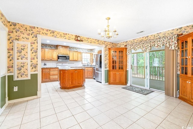 244 George Washington Trl, Georgetown, SC 29440 - kitchen featuring stainless steel appliances, wallpapered walls, wainscoting, a chandelier, and a kitchen island