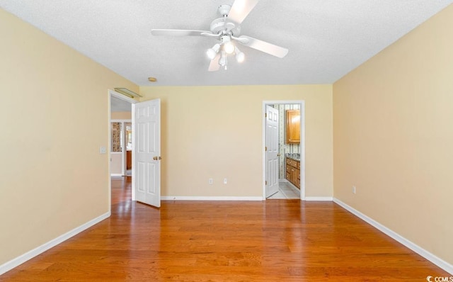 244 George Washington Trl, Georgetown, SC 29440 - unfurnished bedroom featuring light wood finished floors, a textured ceiling, baseboards, ensuite bath, and ceiling fan