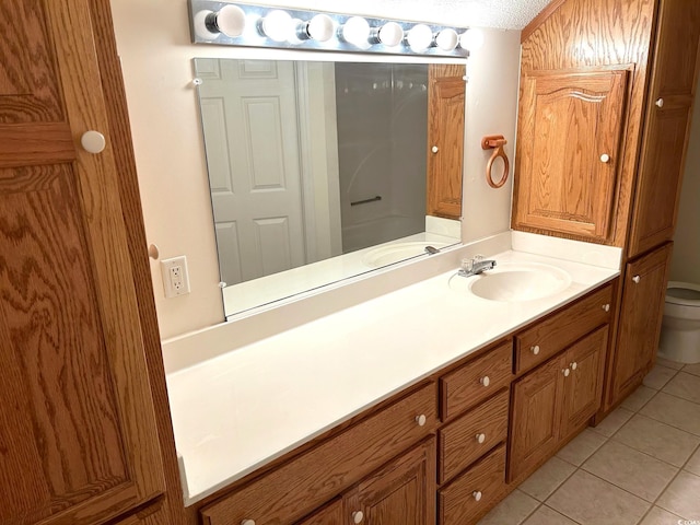 bathroom with vanity, toilet, a textured ceiling, and tile patterned flooring