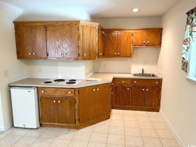 kitchen with sink, light tile patterned floors, and white appliances