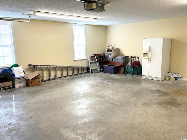 garage featuring a garage door opener and white fridge with ice dispenser