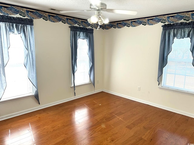 empty room featuring ceiling fan, wood-type flooring, and a textured ceiling