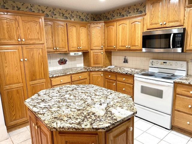 kitchen with tasteful backsplash, a kitchen island, white range with electric stovetop, light stone counters, and light tile patterned floors