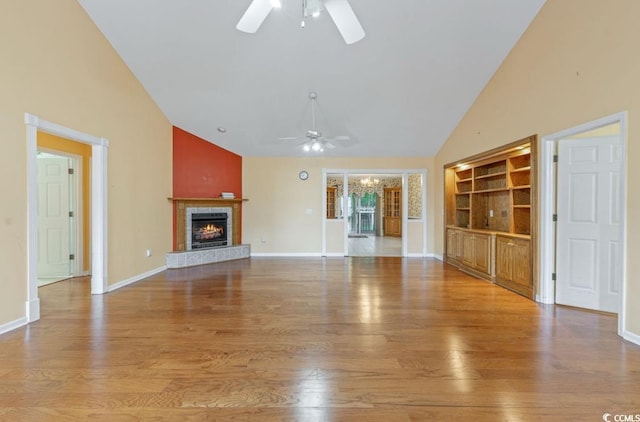 244 George Washington Trl, Georgetown, SC 29440 - unfurnished living room with ceiling fan, high vaulted ceiling, a tiled fireplace, wood finished floors, and built in features