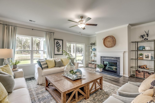 living room with crown molding, a high end fireplace, and wood-type flooring