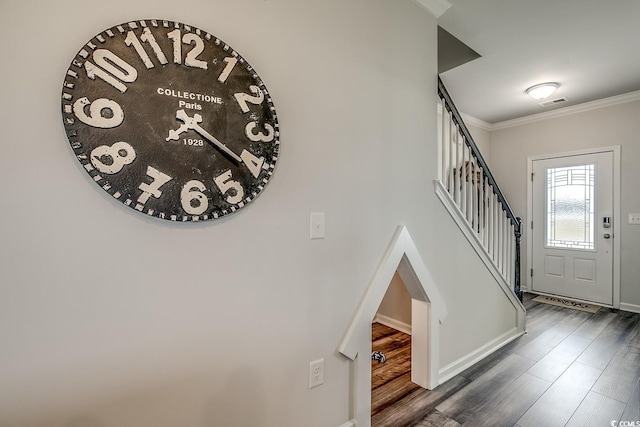 entryway with crown molding and dark wood-type flooring