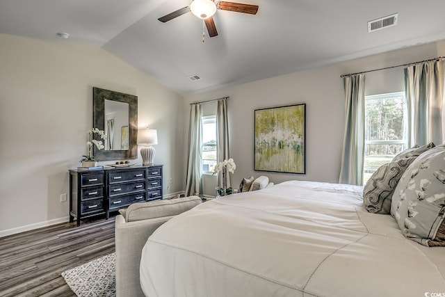 bedroom with multiple windows, vaulted ceiling, hardwood / wood-style flooring, and ceiling fan