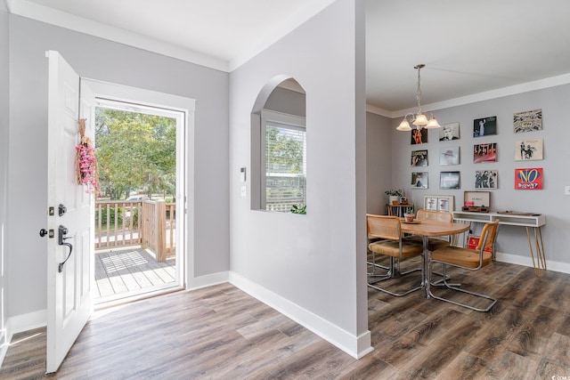 interior space featuring hardwood / wood-style flooring, ornamental molding, and a chandelier