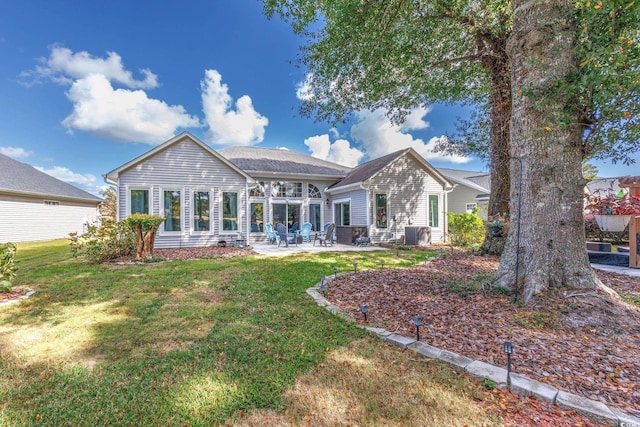 rear view of property featuring a yard and a patio