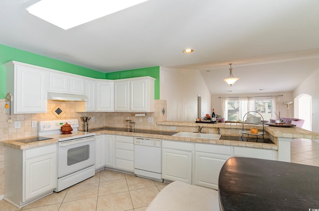 kitchen with white cabinetry, sink, kitchen peninsula, vaulted ceiling, and white appliances