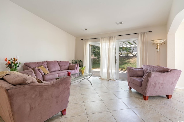 living room with light tile patterned floors and vaulted ceiling