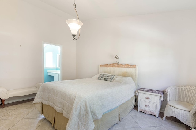 bedroom with light tile patterned floors and ensuite bath