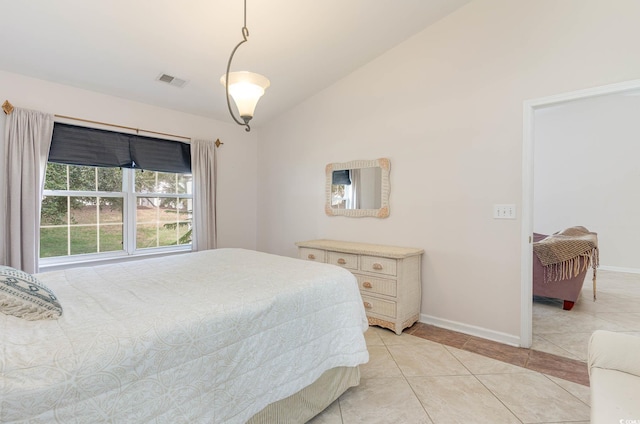 bedroom with light tile patterned floors and vaulted ceiling