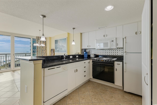 kitchen featuring kitchen peninsula, backsplash, sink, white cabinets, and white appliances