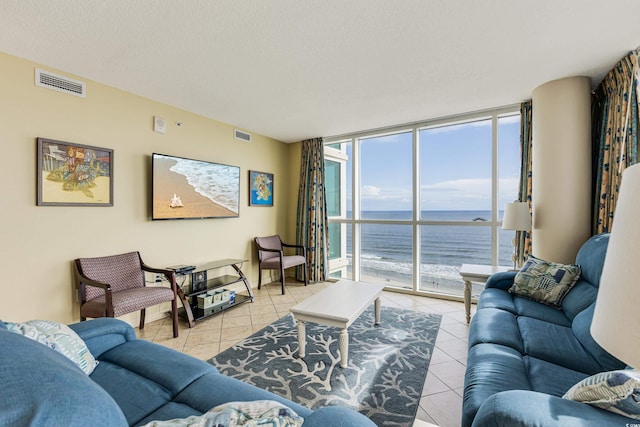 living room with a water view, a healthy amount of sunlight, and light tile patterned floors