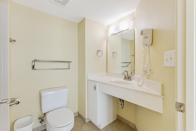 bathroom featuring sink, a textured ceiling, toilet, and tile patterned flooring