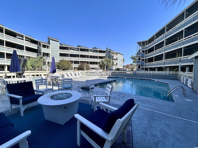pool featuring an outdoor fire pit and a patio area
