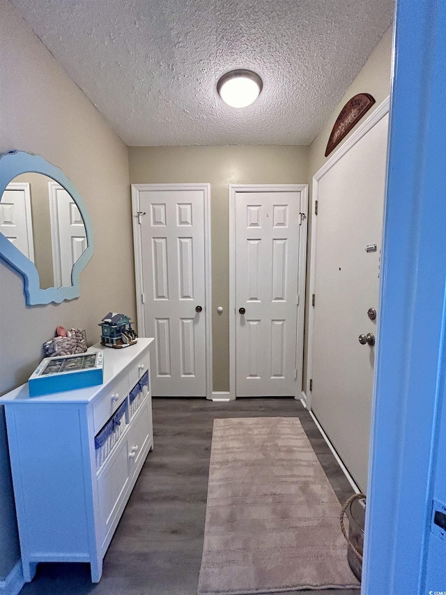 entrance foyer featuring a textured ceiling and dark wood-style flooring