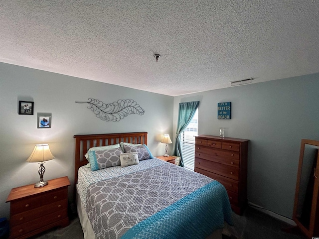 bedroom with visible vents, a textured ceiling, and carpet flooring