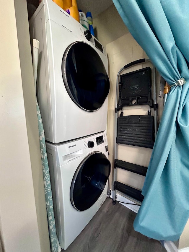 washroom with stacked washing maching and dryer and dark hardwood / wood-style floors